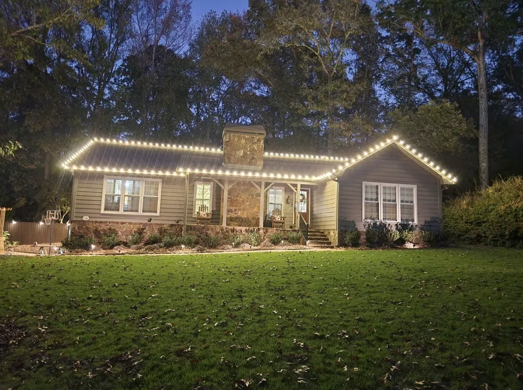 White roofline lights on a single-story ranch home with a stone chimney.